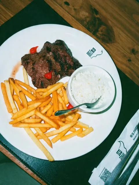 Prato com corte grelhado, batatas fritas e molho